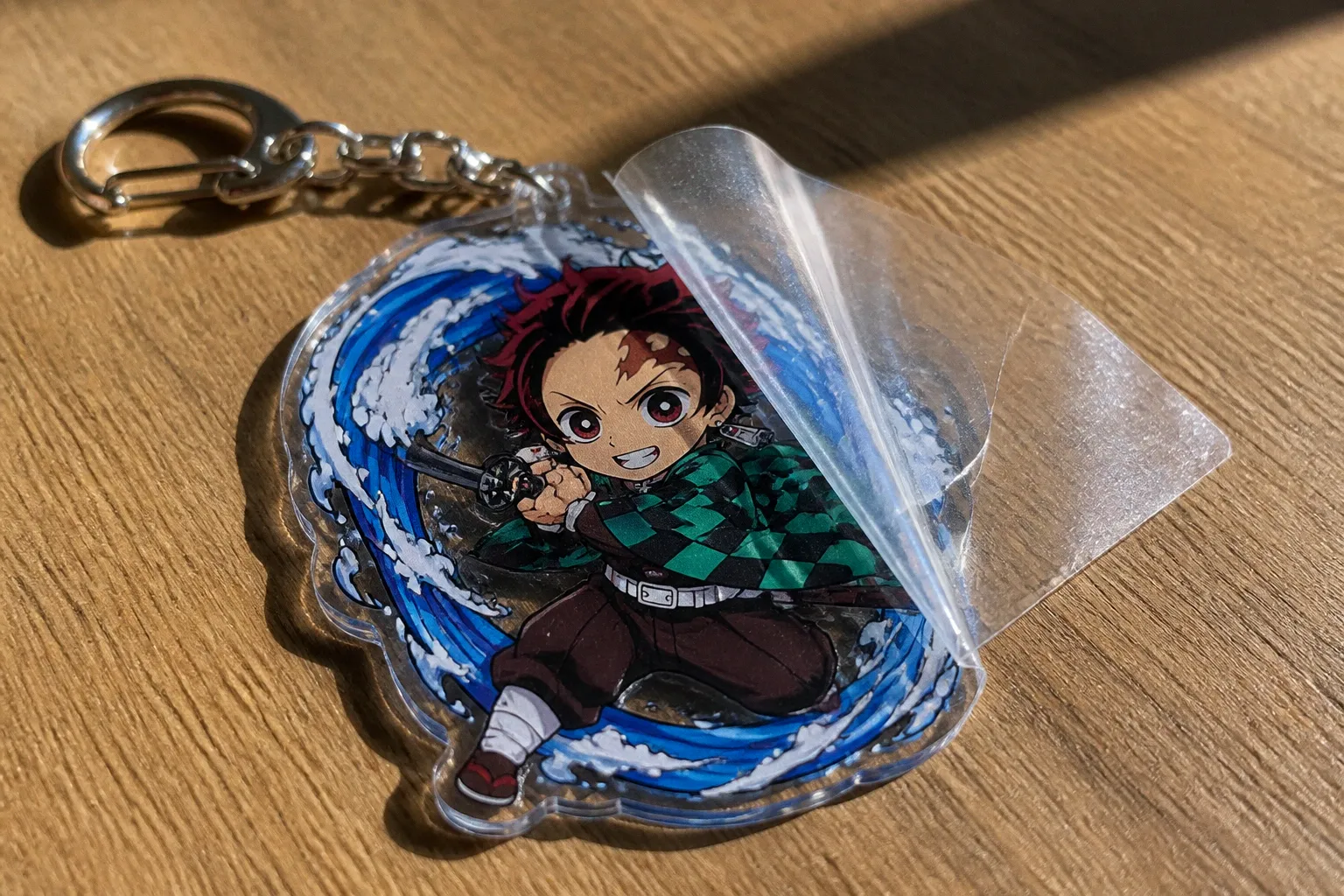 Porte-clés acrylique manga : faut-il retirer le film ?